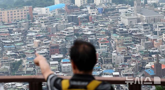 [서울=뉴시스] 추상철 기자 = 5일 오후 서울 용산구 남산에서 시민이 아파트 단지 앞으로 보이는 빌라를 바라보고 있다. 2024.08.05. scchoo@newsis.com