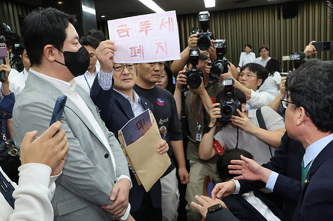 지난 24일 오전 서울 여의도 국회에서 ‘행복하고 정의로운 대한민국, 금융투자소득세 시행은 어떻게?’라는 주제로 열린 더불어민주당 정책 디베이트에서 개인투자자 단체인 한국주식투자자연합회(한투연) 회원들이 토론 방청을 막는 것에 대해 항의하며 금투세 폐지를 촉구하고 있다.[사진=연합뉴스]