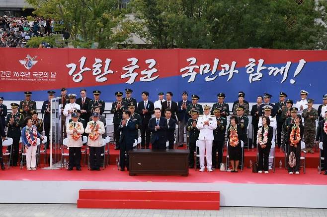 윤석열 대통령이 1일 서울 광화문 일대에서 열린 국군의날 시가행진 중 세종대왕상 앞 관람 무대에서 호국 영웅들 및 유족들과 박수치고 있다. [이미지출처=연합뉴스]