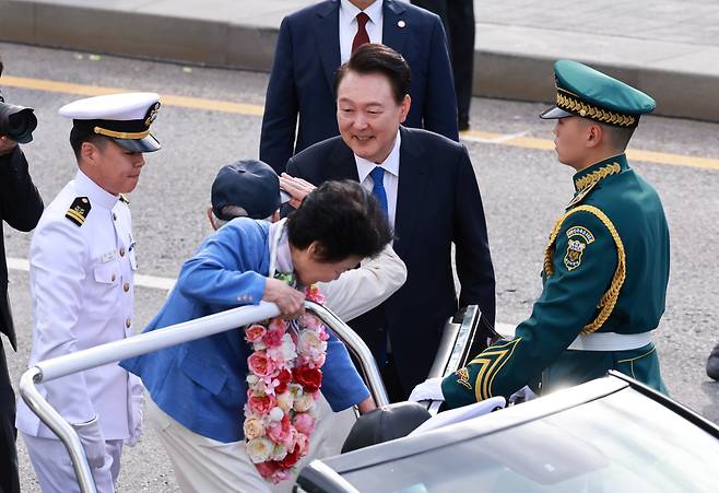 윤석열 대통령이 1일 국군의 날 시가행진에서 광화문광장 관람석에 도착한 송치선·안상정 6·25참전용사를 맞이하고 있다. /연합뉴스