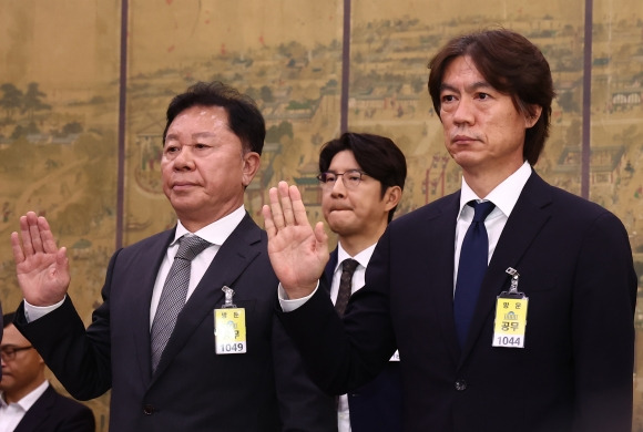 홍명보 한국 남자축구 국가대표팀 감독이 24일 서울 여의도 국회 문화체육관광위원회에서 열린 대한축구협회 등에 대한 현안질의에 출석해 정해성 전 전력강화위원장, 박주호 전 위원 등과 선서하고 있다. 뉴스1