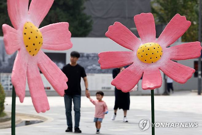 가을 나들이 (광주=연합뉴스) 조남수 기자 = 1일 광주 동구 5·18민주광장에서 시민들이 코스모스 조형물 주위를 걷고 있다. 2024.10.1 iso64@yna.co.kr