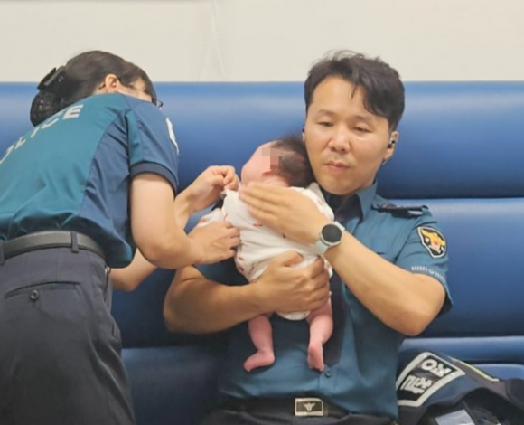 지난달 19일 서울 종로구 관수파출소에 근무하는 경찰관이 거리를 배회 중이던 20대 여성 A씨와 신생아를 파출소로 데리고 와 보호조치하고 있다. 종로경찰서 제공