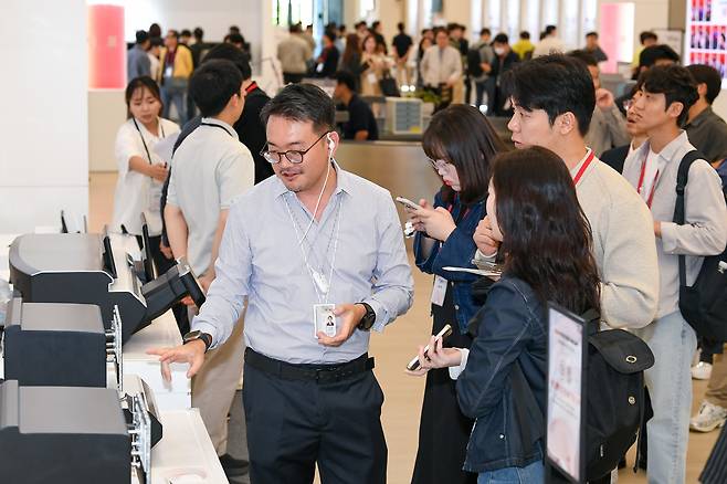 '연구원들이 테크데이 관람회에 온 미디어 기자단에 자사의 신기술을 설명하고 있다.'