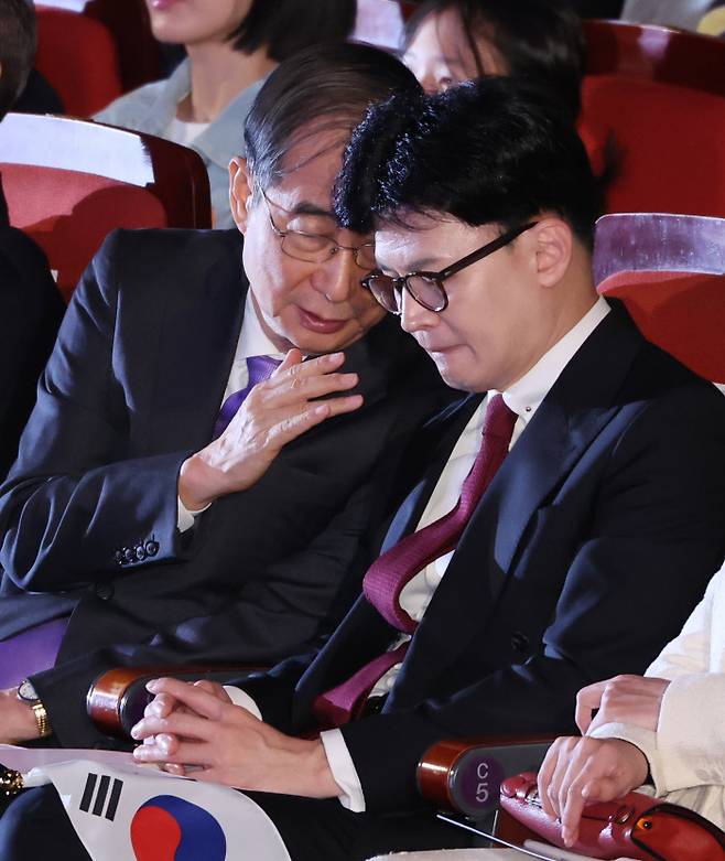 Prime Minister Han Duck-soo (left) talks with Han Dong-hoon, leader of the People\'s Power Party, at the National Foundation Day celebration held at Sejong Center in Seoul on October 3. Yonhap News