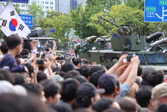 A soldier forms a heart with his arms as a military parade marking the 76th Armed Forces Day passes through Gwanghwamun in downtown Seoul Tuesday. [YONHAP]