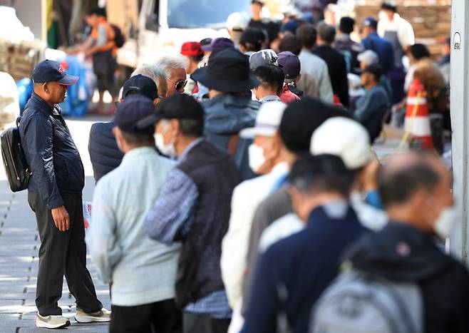 어르신들이 지난 2일 서울 종로구 탑골공원 원각사 노인 무료급식소 앞에 점심식사를 위해 줄지어 서 있다. [사진 출처=연합뉴스]