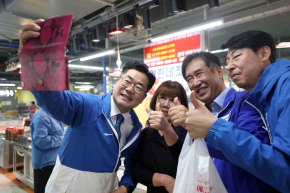 야 원내대표도 강화군수 한 표 호소 - 10·16 인천 강화군수 보궐선거 공식 선거 운동이 시작된 3일 박찬대(왼쪽) 더불어민주당 원내대표가 강화풍물시장을 찾아 지지를 호소하며 시민들과 사진을 찍고 있다. 뉴스1