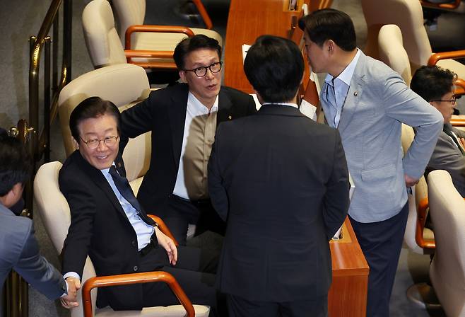 이재명 더불어민주당 대표(왼쪽)와 김민석 의원 등이 4일 오후 열린 국회 본회의에서 윤석열 대통령의 재의 요구로 국회로 돌아온 '김건희 여사 특검법'과 '채상병 특검법', 지역화폐법(지역사랑상품권이용활성화법) 개정안 등 3개 법안과 관련한 투표를 앞두고 대화하고 있다. [연합]