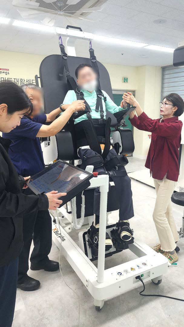 용인 기흥장애인복지관 스마트재활센터에서 한 중증장애인이 보행로봇의 도움을 받으며 재활치료를 하고 있다. [사진제공=용인시]