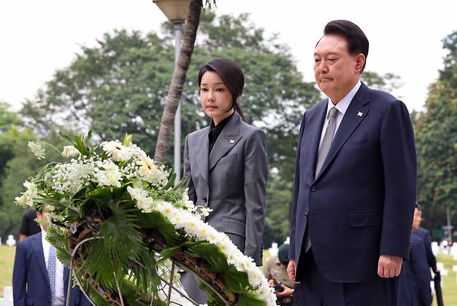 President Yoon Suk Yeol (right) and his wife Kim Keon Hee attends a flower-laying ceremony at the Korean War Memorial Pylon at the Heroes' Cemetery in Manila, the Philippines on Sunday. (Yonhap)