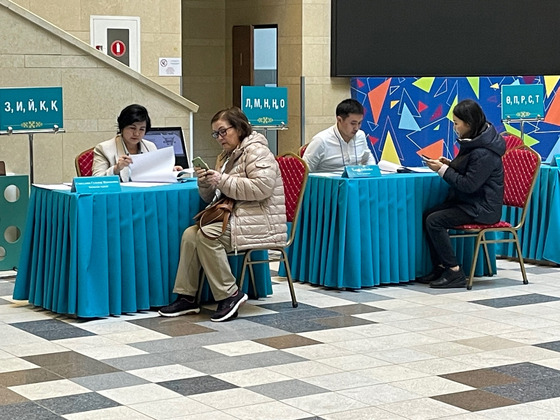 Voters at a polling station in central Astana register their identification for voting with polling station officials on Sunday. The referendum being held the same day, the third in Kazakhstan’s history, will decide whether the country’s first nuclear power plant will be built. [LIM JEONG-WON]