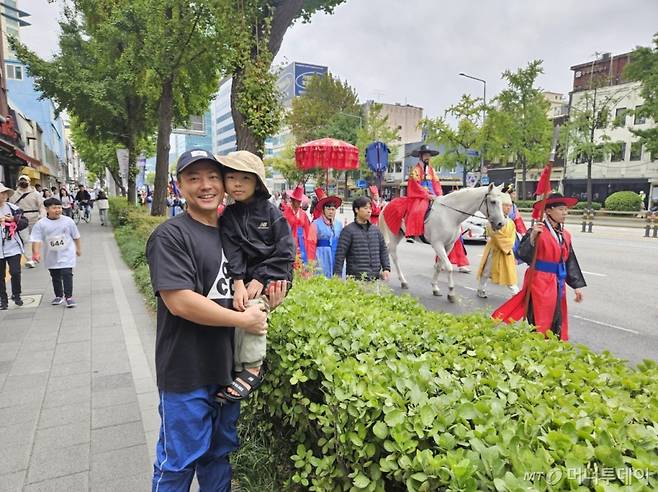 '2024년 정조대왕 능행차 공동 재현' 행사 참가자들이 6일 오전 서울 용산구 한강대로에서 노들섬 방향으로 행진하고 있다. 권용식씨는 아들 현욱군(6·남)과 행렬을 구경했다./사진=정세진 기자