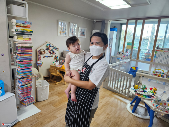 3일 첫 출근한 필리핀 가사관리사가 서울 시내 한 가정에서 아이를 안고 있다.   서울시 제공