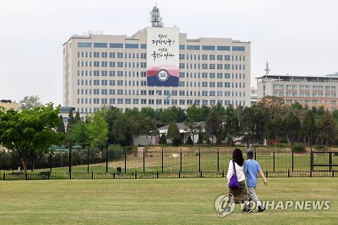 대통령실 앞을 배경삼아 (서울=연합뉴스) 윤동진 기자 = 4일 오후 어린이날을 하루 앞두고 개방된 용산어린이정원에서 한 가족이 잔디마당을 걷고 있다. 2023.5.4 mon@yna.co.kr