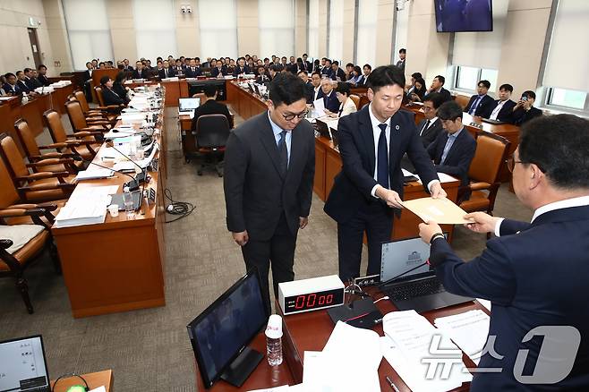 신정훈 국회 행안위원장이 7일 오전 서울 여의도 국회 행정안전위원회 전체회의장에서 열린 행정안전부 등에 대한 국정감사에서 불출석 사유서를 제출하지 않고 국감 출석을 회피한 '대통령 관저 증축' 의혹 증인인 21그램 김태영, 이승만 대표에 대한 동행명령장을 경위들에게 전달하고 있다. 이날 여당 의원들은 동행명령장 발부에 항의하며 국감장을 나갔다.2024.10.7/뉴스1 ⓒ News1 이광호 기자