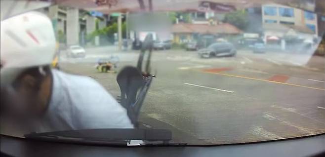 A cyclist is seen colliding with the rear of a parked vehicle in this dashcam footage shared on the online community Bobaedream.
