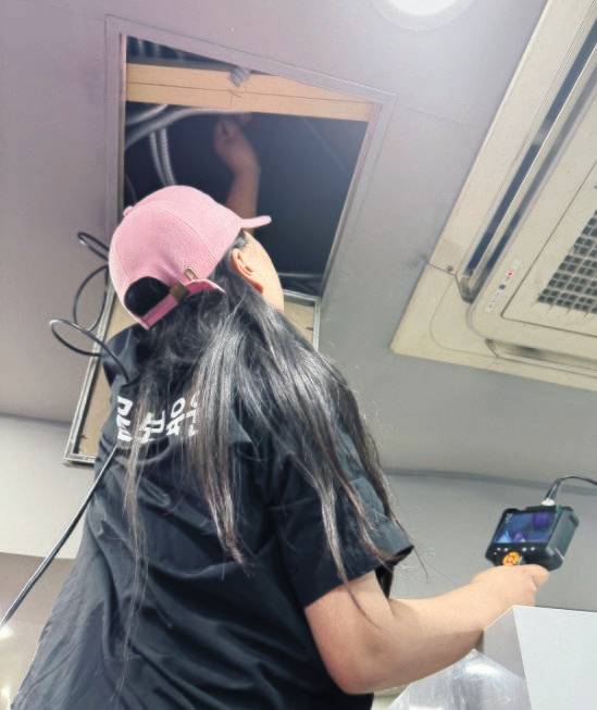 고양이 탐정이 식당 천정에 숨은 고양이를 구조하기 위해 내시경카메라를 동원하고 있다.