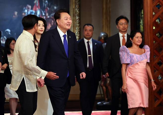 President Yoon Suk Yeol (third from left, front) and his wife Kim Keon Hee (second from left, front) enter the Malacanang presidential palace in Manila, the Philippines as Ferdinand Marcos Jr. (left, front) and his wife Louise Araneta-Marcos (right) receive Yoon and Kim Monday. (Yonhap)