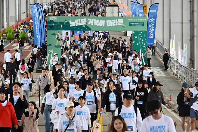 Participants of the Slow Marathon with Pets and their companion pets walk along the Jamsu Bridge -- a submersible bridge connecting Yongsan and Seocho -- on Sunday. (Park Hae-mook/The Korea Herald)