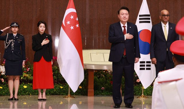 윤석열 대통령과 부인 김건희 여사가 8일 오전(현지시각) 싱가포르 의회에서 열린 공식 환영식에서 애국가 연주를 들으며 국기에 대한 경례를 하고 있다. 싱가포르/연합뉴스