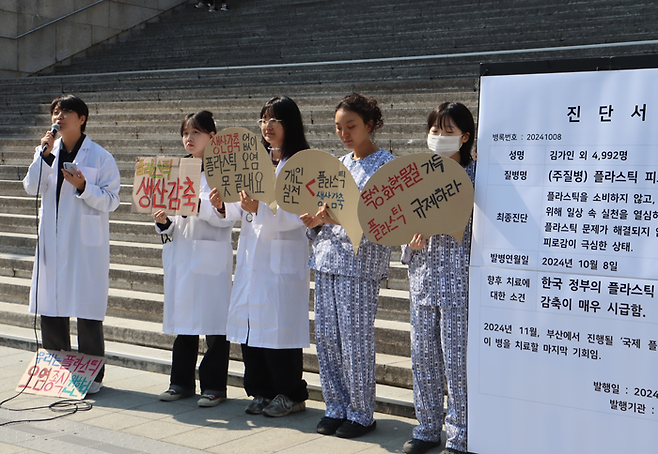 서울환경연합 활동가들이 8일 서울 광화문 세종문화회관 계단 앞에서 플라스틱 피로에 관한 퍼포먼스를 진행하고 있다. 서울환경연합 제공