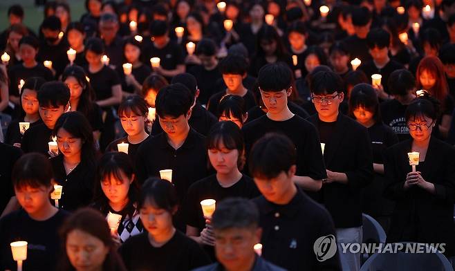 "선배님, 하늘나라에서는 마음 편안하게 지내소서" 순직한 서울 서이초등학교 선생님의 49재 추모일인 2023년 9월 4일 오후 서울 서초구 서울교육대학교에서 촛불문화제가 열렸다. 행사에 참여한 학생들이 묵념하고 있다. 
 [연합뉴스 사진]