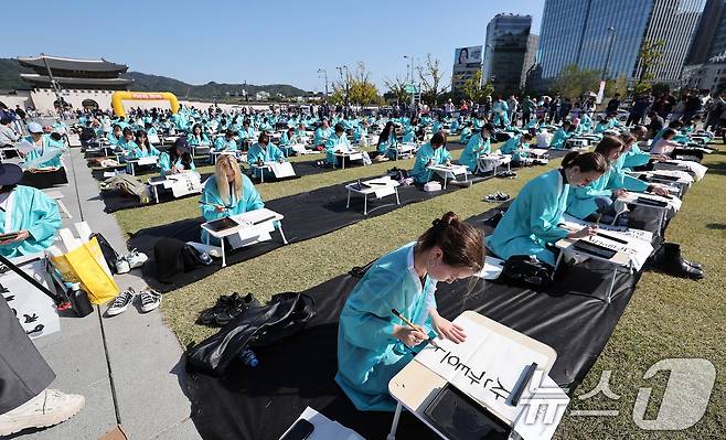 제578돌 한글날을 맞은 9일 오전 서울 종로구 광화문광장에서 한국예술문화원 주체로 열린 조선시대 과거 시험 재현 '휘호대회'에서 외국인 참가자들이 글씨를 적고 있다. 2024.10.9/뉴스1 ⓒ News1 김성진 기자