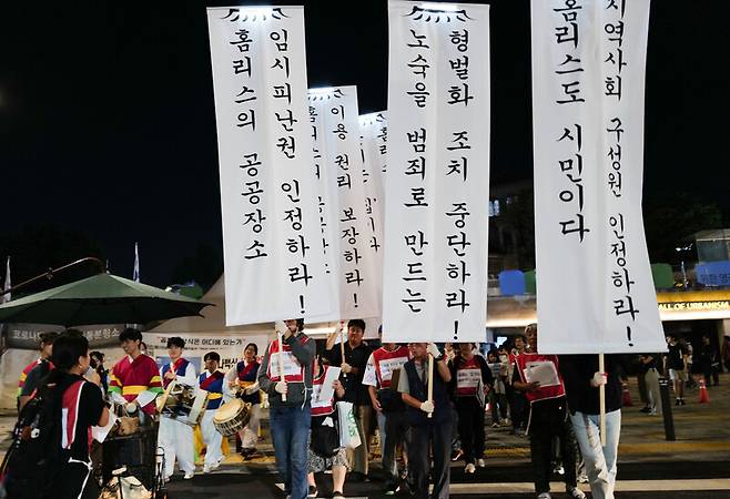 문화제를 마치고 서울광장을 둘러싸는 ‘서울시 포위 행진’을 출발하는 모습. 5개 항의 ‘홈리스의 공존할 권리’ 선언문을 적은 만장이 보인다. 최인기 작가