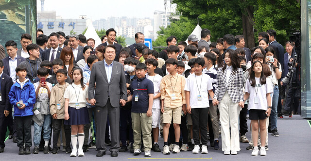 윤석열 대통령 부부가 지난해 5월 용산 어린이정원 개방 행사에 아이들 손을 잡고 입장하고 있다. 대통령실사진기자단