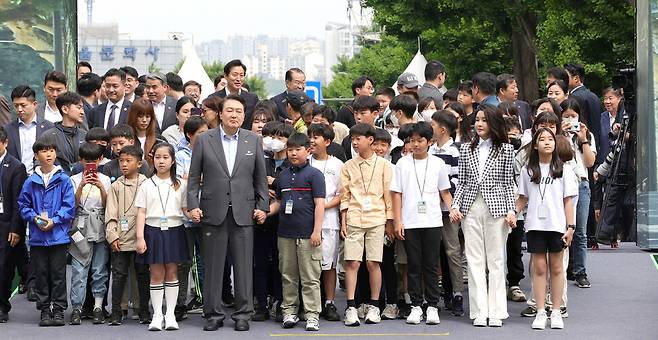 윤석열 대통령 부부가 지난해 5월 서울 용산어린이정원 개방 행사에 아이들 손을 잡고 입장하고 있다. 대통령실사진기자단