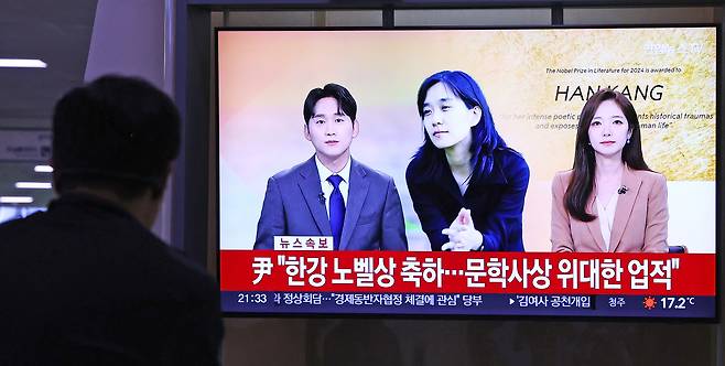 People watch a television broadcast about Korean author Han Kang winning the 2024 Nobel Prize in Literature at Seoul Station in central Seoul on Thursday. [YONHAP]