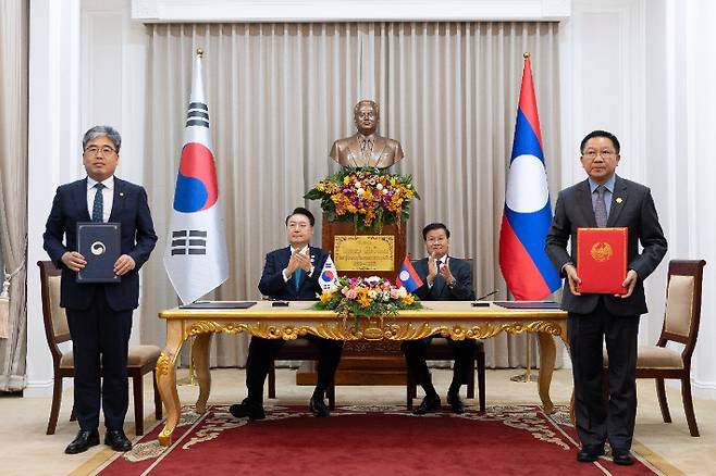 임상섭 산림청장과 린캄 두앙사반 라오스 농림부 장관이 10일(현지시간) 라오스 비엔티안 주석궁에서 윤석열 대통령과 통룬 시술릿 라오스 국가주석이 임석한 가운데 한·라오스 산림 파괴 방지를 통한 온실가스 감축사업(REDD+) 협력에 대한 기관 간 약정을 체결하고 있다. 연합뉴스