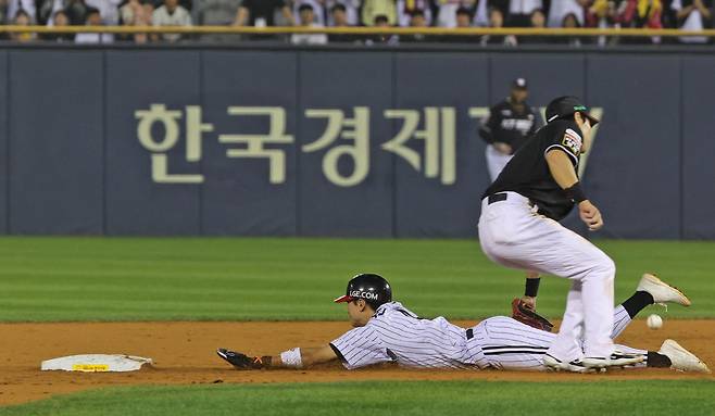 11일 오후 송파구 잠실야구장에서 열린 프로야구 KBO 포스트시즌 준플레이오프 5차전 LG와 KT의 경기, LG 공격 3회말 1사 1루 상황에서 1루주자 신민재의 도루가 성공한 동시에 KT 수비 실책으로 공이 빠지고 있다. /뉴스1