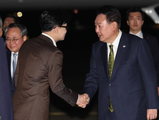 윤석열 대통령이 11일 성남 서울공항에서 귀국하며 마중 나온 한동훈 국민의힘 대표와 악수하고 있다. 연합뉴스