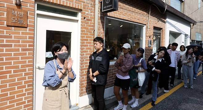 11일 작가 한강이 운영하는 서울 종로구의 동네서점 ‘책방 오늘’에 긴 줄이 늘어서자 책방지기가 나와 질서 유지에 관한 안내를 하고 있다. [김호영 기자]