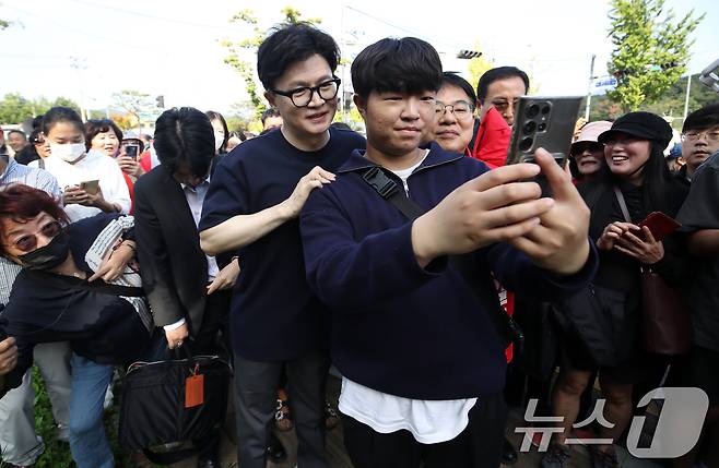 한동훈 국민의힘 대표가 12일 오후 부산 금정구 노포역 일대에서 시민들에게 윤일현 금정구청장 후보에 대한 지지를 호소하며 기념사진을 찍고 있다. 2024.10.12/뉴스1 ⓒ News1 윤일지 기자