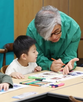 이경국 작가가 지난 10일 서울 교보문고 서울 광화문점 세미나실에서 열린 '함께 그린 책'  행사에서 참석한 어린이의 실습을 도와주고 있다.  /이솔 기자