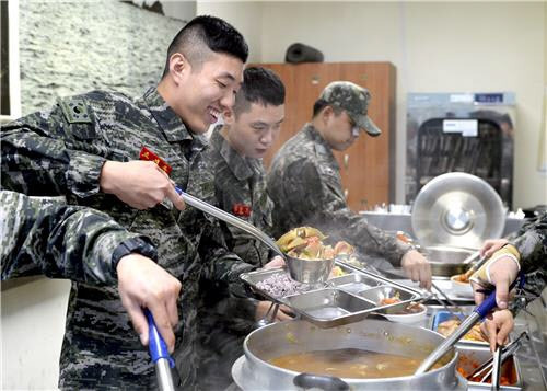 해병대 6여단 병사들이 어민들이 지원한 꽃게로 만든 음식을 식판에 담고 있다. 해병대 6여단 제공