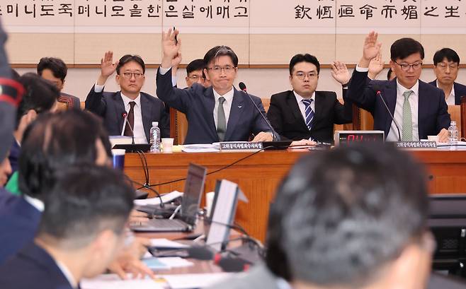 14일 열린 국회 법제사법위 국정감사에서 오동운(앞줄 왼쪽) 고위공직자범죄수사처장 등 공수처 직원들이 “공수처가 존속돼야 한다고 생각하는 분은 손을 들어보라”는 국민의힘 곽규택 의원 발언에 모두 손을 들고 있다. /연합뉴스