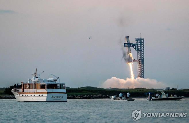 스페이스X의 슈퍼헤비 로켓이 발사 후 귀환해 '젓가락 팔' 모양의 발사탑에 성공적으로 포착되는 모습  [AFP=연합뉴스. 재판매 및 DB 금지]