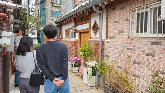 지난 13일 서울 종로구 누하동에 있는 한강 작가 자택 겸 작업실로 알려진 한옥 주택 앞에 축하 화환들이 놓여 있는 모습. 지나가던 시민들이 발길을 멈추고 인증 사진을 찍고 있다. 김서원 기자