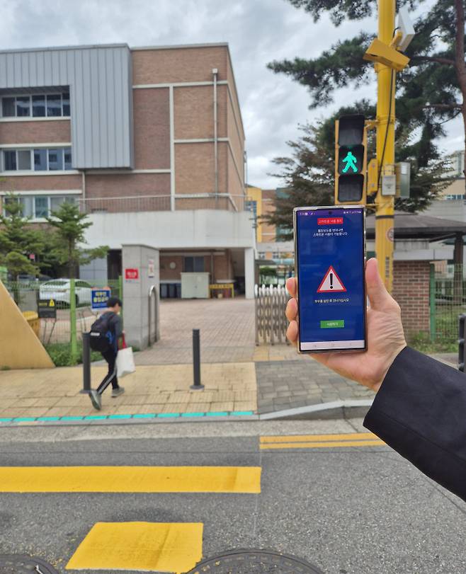 횡단보도에서 보행자 녹색신호가 들어오자 스마트폰에서 화면 차단 서비스가 실행되고 있다. 부천시 제공