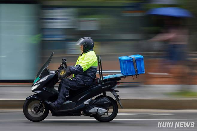 서울 대부분 지역에서 오전 한때 비가 내린 15일 서울 구로구 가산디지털단지역 근처에서 한 시민이 우의를 입은 채 오토바이를 운전하고 있다.