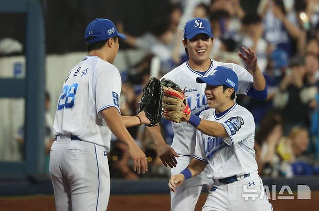 [대구=뉴시스] 김금보 기자 = 15일 오후 대구 수성구 삼성라이온즈파크에서 열린 2024 KBO 포스트시즌 플레이오프 2차전 LG 트윈스와 삼성 라이온즈의 경기, 7회초 무실점으로 이닝을 마친 삼성 김윤수와 선발 원태인이 동료들과 기쁨을 나누고 있다. 2024.10.15. kgb@newsis.com