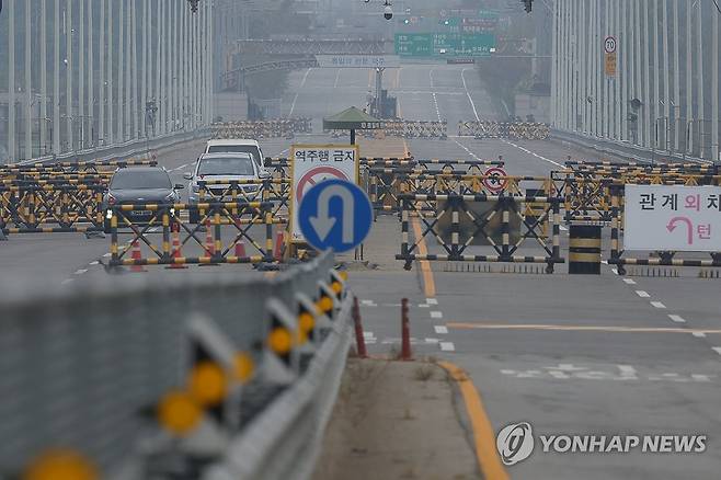 흐릿한 통일대교 (파주=연합뉴스) 임병식 기자 = 북한이 경의선·동해선 남북 연결도로 일부 구간을 폭파한 15일 오후 경기도 파주시 통일대교 남단에서 차량이 임진강을 건너고 있다. 2024.10.15 andphotodo@yna.co.kr