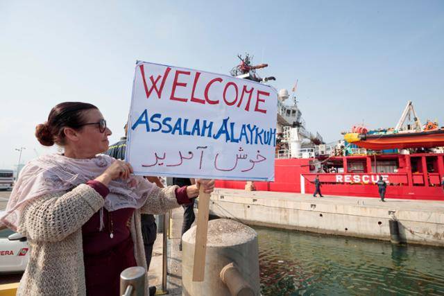 이탈리아 마리나 디 라벤나에서 15일 이민자들이 탑승한 비정부기구(NGO) 선박 '오션 바이킹'이 도착하자 한 시민이 환영하는 팻말을 들고 서 있다. 이 선박에는 이집트, 파키스탄, 시리아, 방글라데시에서 온 47명의 이민자들이 탑승해 있으며 이탈리아 북부 에밀리아노라냐주에 머물 예정이다. 마리나 디 라벤나=EPA 연합뉴스