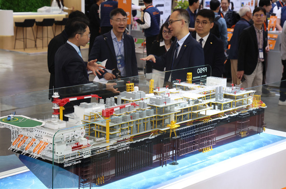 Visitors view models at Hanwha Ocean's booth at Offshore Korea 2024 at the Bexco convention center in Busan on Wednesday. [YONHAP]