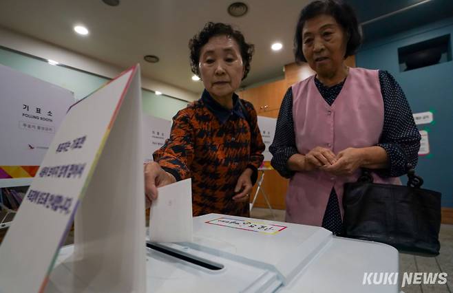 16일 서울 구로구 구로아트밸리 1층 로비에 마련된 투표소에서 박모(79)씨와 지인이 투표함에 투표지를 넣고 있다.