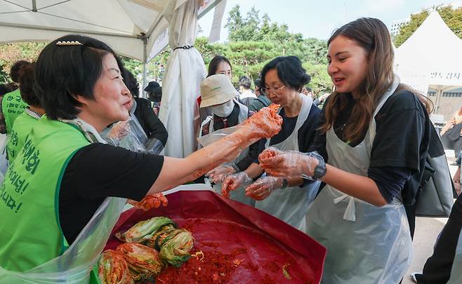 16일 서울 중구 남산골 한옥마을에서 열린 제1회 대한민국 김장김치 축제에서 스위스에서 온 관광객들이 김장 김치 담그기 체험 중 김치를 맛보고 있다.